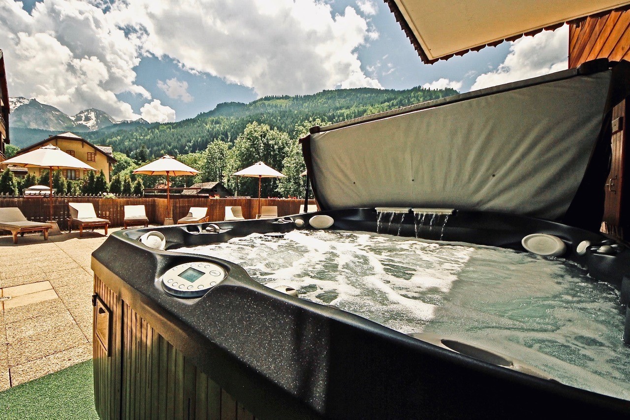 Jacuzzi and solarium on a sunny day, overlooking the Aravis Mountains